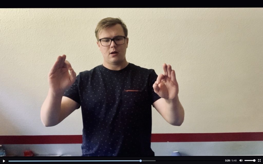 Ausschnitt aus Studierendenvideo, in dem eine Person eine Dirigierübung vormacht. 
